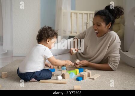 Amare felice mamma biraciale giocare con il bambino Foto Stock