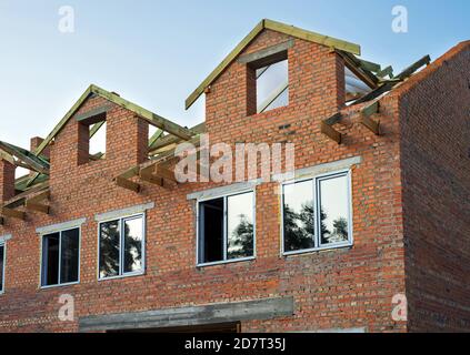 Casa incompiuta di mattoni, ancora in costruzione prima di installare il tetto. Foto Stock