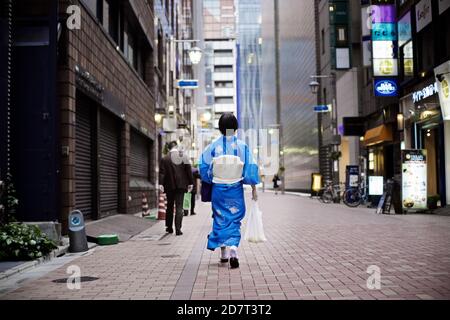 Donna giapponese vestita in kimono e OBI camminando per la strada del reparto Ginza, Tokyo, Giappone 2012 Foto Stock