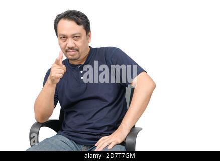 Un uomo di mezza età con una barba in una T-shirt blu e jeans che puntano alla telecamera isolata su sfondo bianco. Foto Stock