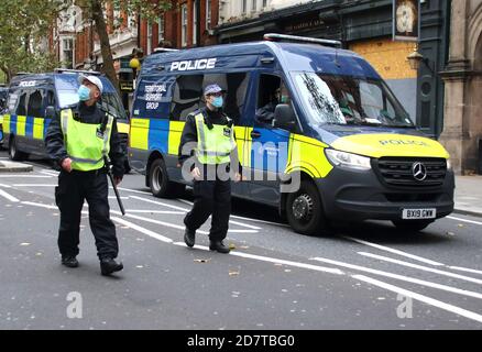 Due ufficiali che indossano mascherine con il gruppo di supporto territoriale (TSG) van a sostegno, pattugliano la rotta del marzo.con un certo numero di dimostrazioni previste che hanno luogo nella capitale questo fine settimana, la polizia metropolitana ha mobilitato personale da tutti i quartieri. Gruppo di supporto territoriale (TSG) l'unità operativa per l'ordine pubblico del MET, ha montato la polizia, le moto e altri veicoli più un gran numero di ufficiali a piedi. Foto Stock