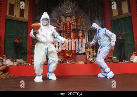 Kolkata, India. 25 Ott 2020. I devoti indù che indossano il PPE eseguono la danza tradizionale di Dhunuchi di fronte alla dea indù Durga idol durante il Durga Puja Festival a Kolkata. Circa il 90 per cento dei pazienti di Covid si sono guariti finora in India, ha detto il Ministero della Sanità questa mattina, aggiungendo che il paese ha registrato oltre 78.64 casi di lakh dall'inizio della pandemia. Nelle ultime 24 ore, il paese ha riportato 50,129 nuove infezioni; 578 decessi al giorno hanno portato il totale dei decessi legati a Covid a 1, 18,534. L'India è il secondo paese più colpito al mondo dalla pandemia dopo il Foto Stock