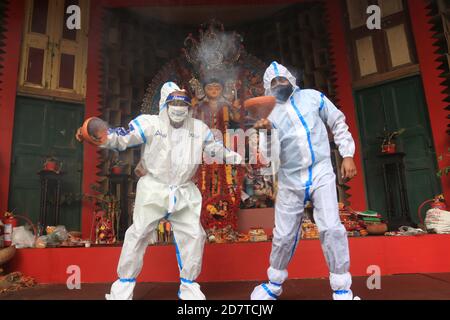 Kolkata, India. 25 Ott 2020. I devoti indù che indossano il PPE eseguono la danza tradizionale di Dhunuchi di fronte alla dea indù Durga idol durante il Durga Puja Festival a Kolkata. Circa il 90 per cento dei pazienti di Covid si sono guariti finora in India, ha detto il Ministero della Sanità questa mattina, aggiungendo che il paese ha registrato oltre 78.64 casi di lakh dall'inizio della pandemia. Nelle ultime 24 ore, il paese ha riportato 50,129 nuove infezioni; 578 decessi al giorno hanno portato il totale dei decessi legati a Covid a 1, 18,534. L'India è il secondo paese più colpito al mondo dalla pandemia dopo il Foto Stock