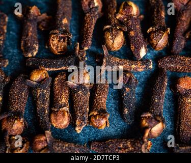 Primo piano di chiodi di garofano su uno sfondo blu scuro girato in alto Foto Stock