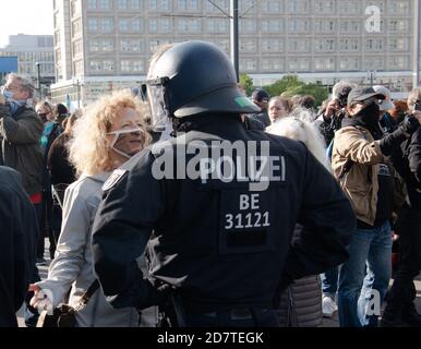 Berlino, Germania. 25 Ott 2020. Un partecipante alla manifestazione contro le restrizioni di Corona parla con un poliziotto ad Alexanderplatz. Credit: Paul Zinken/dpa/Alamy Live News Foto Stock