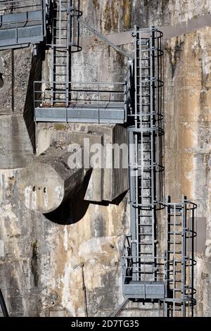 Scale di sicurezza industriale, scale a muro, scale di sicurezza e piattaforme di lavoro fissate a parete in cemento di Castillon Dam o Barrage Provence Francia Foto Stock