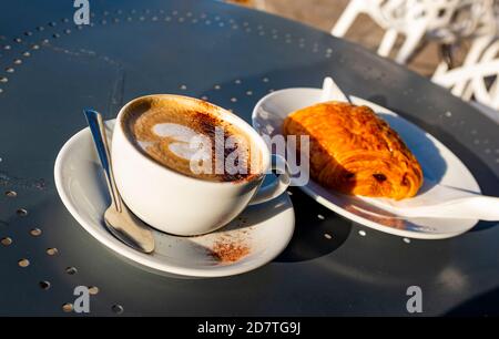 Pasta Pain au Chocolate su un piatto con un cappuccino caffè Foto Stock