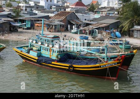 Barca da pesca in colori Nha trang e pronta per la pesca notturna all'ancora accanto al villaggio di pescatori nel porto di Phan Thiet. Foto Stock