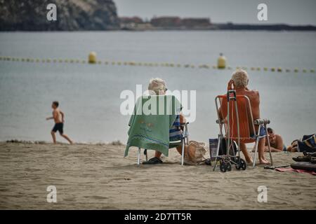 Los Cristianos, Spagna. 25 Ott 2020. I turisti godono del sole sulla spiaggia la Playa de Las Vistas, nel sud delle Isole Canarie. I turisti tedeschi e britannici sono arrivati sull'isola delle Canarie questo fine settimana, dopo che le isole Canarie sono state nuovamente tolte dalla lista dei rischi a causa del numero di infezioni in diminuzione. Per contenere il rapido aumento del numero di infezioni corona, il governo spagnolo ha nuovamente dichiarato un'emergenza nazionale. L'ordine si applica praticamente a tutto il paese, ad eccezione delle isole Canarie. Credit: Andrés Gutiérrez/dpa/Alamy Live News Foto Stock