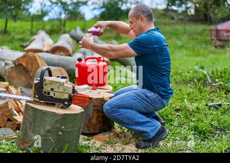 Lumberjack ricarica la motosega con una miscela specifica di gas e