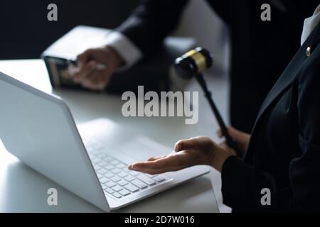 Gli avvocati discutono con il computer portatile alla scrivania Foto Stock