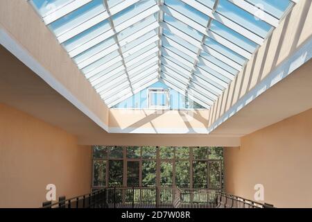 Tetto di vetro trasparente sulla sommità di un edificio moderno. Corridoio per edifici aziendali con luce naturale. Vista dal basso Foto Stock