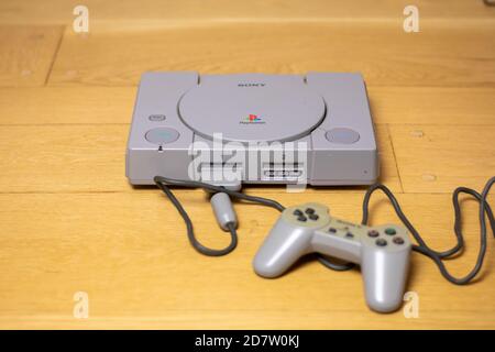 Una PlayStation 1 originale, di Sony, su un pavimento in legno. Foto Stock