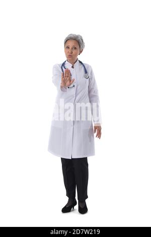 Medico femminile maturo asiatico con stetoscopio che mostra il gesto di stop isolato su sfondo bianco Foto Stock