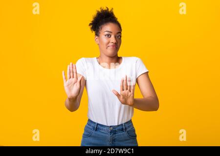 Donna di balck seria che mostra il segno di stop con le mani Foto Stock