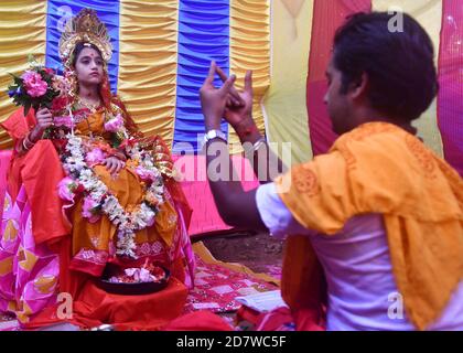 Chitrakshi Chakraborty età 10 anni e 9 giorni vestita come Kumari, è una giovane ragazza vergine che è adorata come parte dei rituali di Durga Puja. Il festival è il più grande evento religioso per gli indù bengalesi. Gli indù credono che la dea Durga simbolizzi il potere e il trionfo del bene sul male. Agartala, Tripura, India. Foto Stock