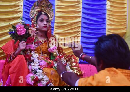 Chitrakshi Chakraborty età 10 anni e 9 giorni vestita come Kumari, è una giovane ragazza vergine che è adorata come parte dei rituali di Durga Puja. Il festival è il più grande evento religioso per gli indù bengalesi. Gli indù credono che la dea Durga simbolizzi il potere e il trionfo del bene sul male. Agartala, Tripura, India. Foto Stock