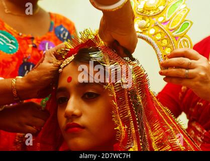 Chitrakshi Chakraborty età 10 anni e 9 giorni vestita come Kumari, è una giovane ragazza vergine che è adorata come parte dei rituali di Durga Puja. Il festival è il più grande evento religioso per gli indù bengalesi. Gli indù credono che la dea Durga simbolizzi il potere e il trionfo del bene sul male. Agartala, Tripura, India. Foto Stock