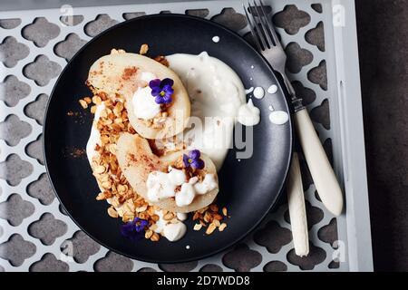 Pera in camicia con cannella, yogurt e granola di avena. Foto Stock