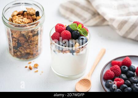 Yogurt greco con muesli e bacche in vasetto. Dessert salutare, colazione o spuntino Foto Stock