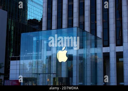 New York, NY - 14 ottobre 2020: Il logo Apple è illuminato con una luce calda in una giornata buia all'Apple Store sulla 5th Avenue, Manhattan. Il vetro Foto Stock