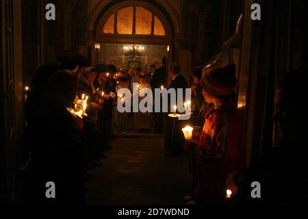 Pasqua serale in una chiesa cristiana ortodossa in Romania. Credenti che tengono il Santo fuoco celebrando la risurrezione di Cristo. Foto Stock