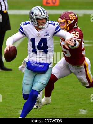 Landover, Stati Uniti. 25 Ott 2020. Il quarto di Dallas Cowboys Andy Dalton (14) evade il linebacker Cole Holcomb (55) della Washington Football Team durante la prima metà di una partita di football della NFL al FedEx Field di Landover, Maryland, domenica 25 ottobre 2020. Foto di David Tulis/UPI Credit: UPI/Alamy Live News Foto Stock