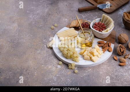 Tavola di formaggi con formaggi, noci, miele e uva, spazio copia Foto Stock