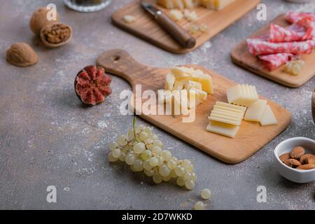 Formaggi assortiti, salumi, noci su tavole di legno, spazio per fotocopie Foto Stock