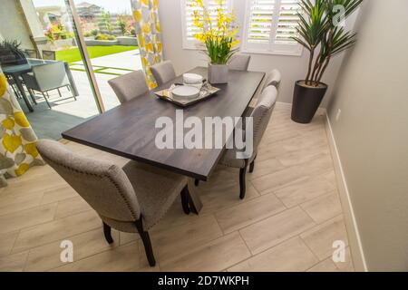 Zona pranzo con tavolo in legno e sei sedie con schienale alto Foto Stock