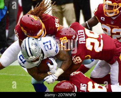 Landover, Stati Uniti. 25 Ott 2020. Dallas Cowboys Running back Ezechiel Elliott (21) è soffocato dai difensori della Washington Football Team durante la prima metà di una partita di football NFL al FedEx Field di Landover, Maryland, domenica 25 ottobre 2020. Foto di David Tulis/UPI Credit: UPI/Alamy Live News Foto Stock