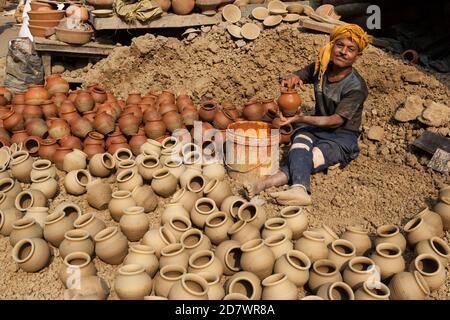 Un vasaio che aggiunge smalto alle pentole della città vecchia Di Delhi Foto Stock