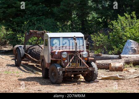 Prospetto, Oregon / USA - 16 agosto 2014: Una jeep antica con un rimorchio che trasporta un grande ceppo al Prospect Hillbilly Jamboree e Carnevale di legname i Foto Stock