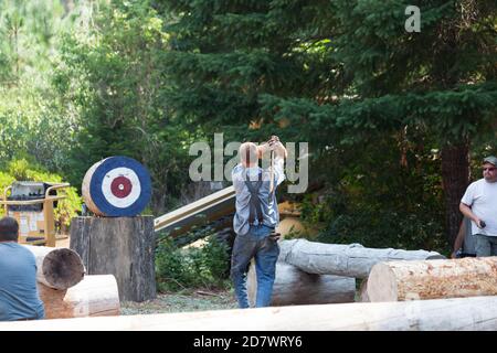 Prospect, Oregon / USA - 16 agosto 2014: Un uomo si prepara a lanciare un'ascia a un bersaglio durante una gara al Prospect Hillbilly Jamboree e Timbe Foto Stock