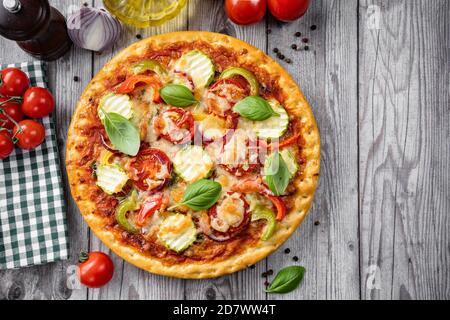 Primo piano di pizza vegetariana croccante su rustico sfondo di legno Foto Stock