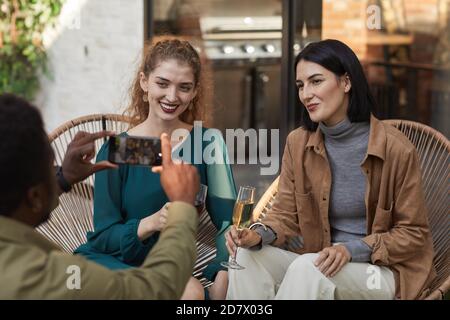 Ritratto di due eleganti donne che posano per scattare foto e sorridere con la fotocamera mentre si gode una festa all'aperto, copy space Foto Stock