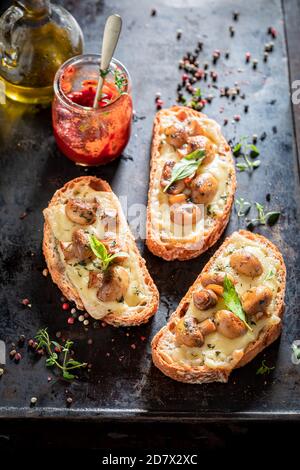 Toast croccante fatto di funghi, formaggio e pepe su vecchia teglia da forno Foto Stock