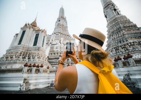 Giovane donna viaggiatore che scatta foto con il suo viaggio mobile a. Thailandia con cappello a Bangkok Thailandia Foto Stock