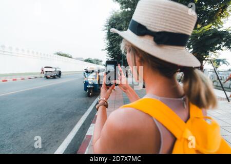 Giovane donna viaggiatore che scatta foto con il suo viaggio mobile a. Thailandia con cappello a Bangkok Thailandia Foto Stock