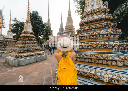 Giovane donna che scatta foto con il suo viaggio mobile in Thailandia Con il cappello che cammina a Wat Pho a Bangkok Thailandia Foto Stock