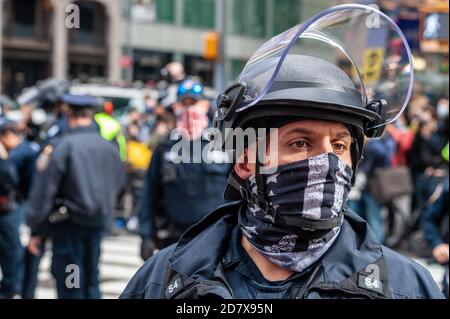 Un ufficiale della NYPD indossa una sottile maschera blu in un rally Trump a Times Square a New York il 25 ottobre 2020. (Foto di Gabriele Holtermann/Sipa USA) Credit: Sipa USA/Alamy Live News Foto Stock