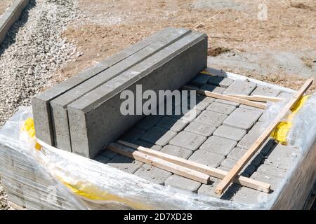 Piastrelle di strada impilate l'una sull'altra. Le lastre per pavimentazione in cemento grigio sono pronte per lavori di costruzione. Pavimentazione stradale, costruzione. Riparazione del marciapiede. Foto Stock