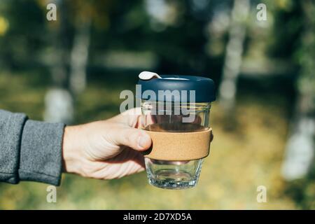 Uomini che tengono una tazza di caffè da asporto. Nessun rifiuto, eco-compatibile, articolo riutilizzabile. Foto Stock