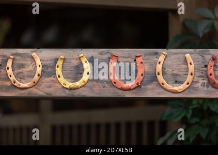 Fortunato ferro di cavallo appeso sulla tavola di legno. Ferro di cavallo per cavalli Foto Stock