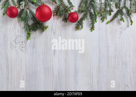 Giocattoli rossi di Natale, rami di abete rosso su sfondo di legno. Vista dall'alto, arredamento di Natale e Capodanno. Il posto per il testo e il vostro prodotto qui, lifestyle Foto Stock