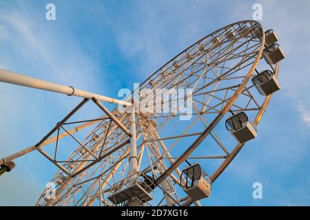 Ruota panoramica contro il cielo blu al tramonto Foto Stock