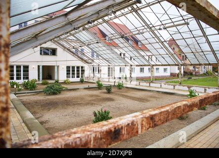 14 ottobre 2020, Brandeburgo, Lychen: Edifici già ristrutturati sorgono nella zona del 'Parkresidenz Lychen', solo il tetto in vetro dell'area d'ingresso non è stato ancora rinnovato. Le case del parco sullo Zenssee fanno parte dell'ex sanatorio di Hohenlychen. Nell'ex sanatorio, il 40 per cento delle case sono già state rinnovate, ci sono appartamenti per due, quattro e sei persone, e 44 appartamenti in affitto senza barriere sono stati sviluppati e la maggior parte di loro sono già occupati. A causa del suo significato urbano, storico e architettonico, il complesso è sul marchio Foto Stock