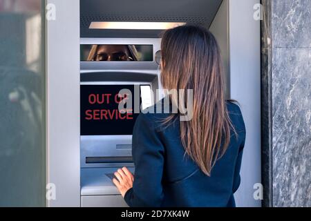 La signora non può prelevare denaro contante dalla carta di credito presso la macchina bancaria. Bancomat fuori servizio, macchina bancaria rotta Foto Stock