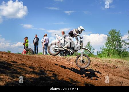 Moto in volo contro il cielo blu. Il pilota fa un salto. Salto di un motociclista Foto Stock