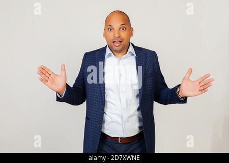 Ritratto di giovane imprenditore afro-americano sorpreso, celebrando pazzo e sopraffatto con successo con mani alzate e occhi aperti, gridando eccitato. Concetto vincitore. Foto Stock